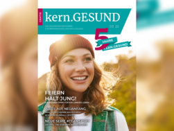 Cover der dritten Ausgabe der kern.GESUND im Jahr 2022. Zu sehen ist das Portrait einer Frau. Sie hat lockige Haare, trägt eine Mütze und lächelt, während sie leicht nach oben schaut.